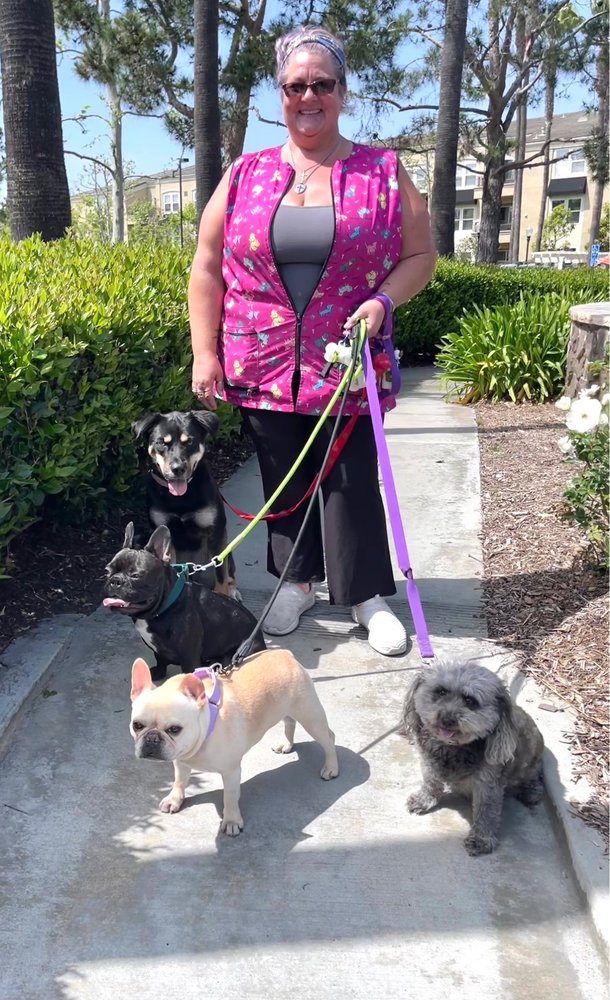 Naomi of Joyful PawZ Pet Services walking four happy dogs